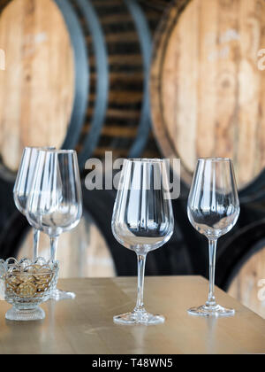 Verres à vin vide en face de tonneaux de vin en bois. Banque D'Images