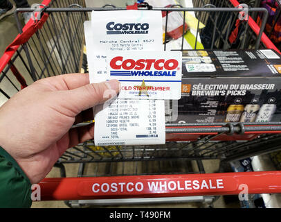 Montréal, Canada - 6 avril 2019 : Une main tenant un reçu et une carte de membre de Costco Costco en entrepôt. Costco est une société américaine qui ope Banque D'Images