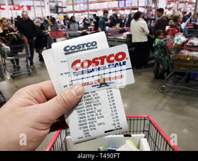 Montréal, Canada - 6 avril 2019 : Une main tenant un reçu et une carte de membre de Costco Costco en entrepôt. Costco est une société américaine qui ope Banque D'Images