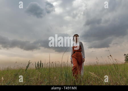 KHORTYTSIA, UKRAINE - Juillet 03, 2018 : blanc femme en robe médiévale marche dans la steppe avec thunder ciel été paysage sur Khortytsia isl Banque D'Images