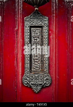 Ornate Old Fashioned la boîte aux lettres ou boîte aux lettres sur une porte rouge Banque D'Images