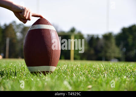 Close-up du football qui aura lieu sur un terrain de football avec un poteau de but dans l'arrière-plan Banque D'Images