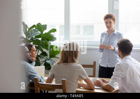 L'équipe d'entreprises multiculturelles avec femme chef avoir conversation at meeting Banque D'Images