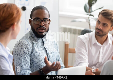 African mentor expliquant caucasian stagiaires nouvelle stratégie à la réunion Banque D'Images