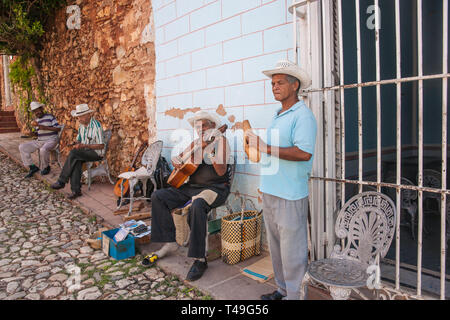 TRINIDAD Cuba le 2 juillet 2012 ; les musiciens de village-rue avec guitare assis et debout en face de mur avec de la peinture à l'affiche pour les touristes. Banque D'Images