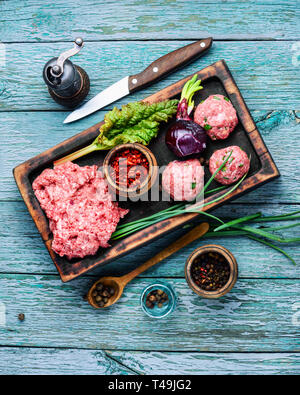 La viande hachée fraîche sur une planche à découper et les ingrédients de la viande hachée mélangée.Raw boulettes Banque D'Images