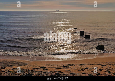 Voile sur l'horizon avec des rochers, plage de sable et de soleils réflexion sur mer méditerranée, Palma, Majorque, Espagne. Banque D'Images