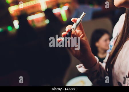 Pas de chaleur-brûler du tabac produit de la technologie. Woman holding e-cigarette dans sa main avant de fumer. Banque D'Images