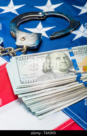 Tas de l'argent et les menottes sur drapeau américain close up concept photo Banque D'Images