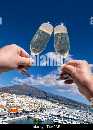 Vin mousseux acclamations vacances luxe Champagne style de vie alfresco chinking, vacances vista Puerto Banús marina Marbella Costa del sol Andalousie Espagne Banque D'Images