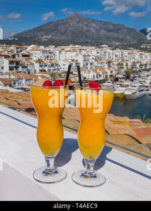 Puerto Banús Marbella espagnol frais jus d'orange naturel verres, sur le luxe en plein air bar terrasse de l'hôtel avec vue sur port de plaisance Puerto Banús Marbella espagne Banque D'Images