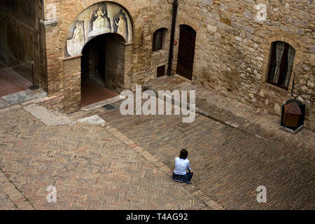 Une dame se trouve dans la jolie cour dans le Palazzo del Popolo prises à partir de la loggia, San Gimignano, Toscane, Italie. Parution du modèle Banque D'Images