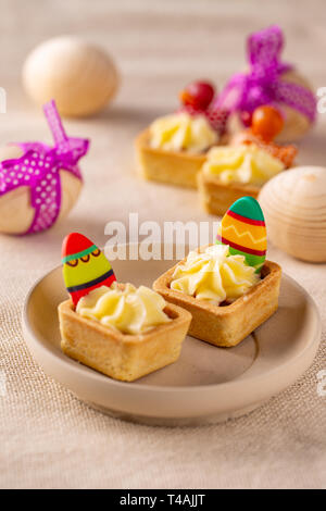 Minis gâteaux avec de la crème vanille chocolat décoré avec des oeufs de l'Ester Banque D'Images