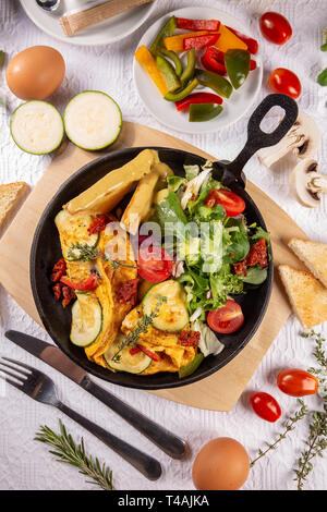 Omelette aux légumes servi avec des tomates cerises et laitue Banque D'Images