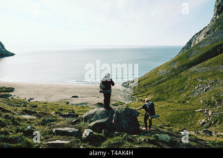 Randonneurs sur le sentier de la plage de Kvalvika sur la côte nord-est de l'Moskenesøya in Flakstad îles Lofoten Nordland en Norvège. Banque D'Images