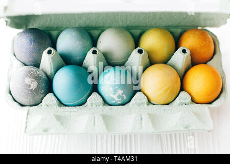 Joyeuses Pâques. Oeufs de Pâques en élégantes couleurs pastel arc-en-ciel en plateau sur fond de bois blanc, de l'espace pour le texte. La douleur d'oeufs de Pâques colorés modernes Banque D'Images