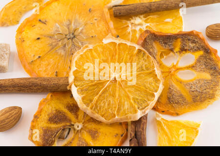 Un fond blanc dans un style chaleureux. Tranches d'orange séchée, les kakis et les amandes. Mise à plat. Banque D'Images