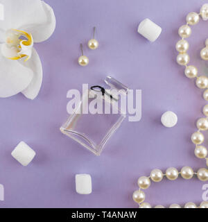 Girly télévision jeter l'arrière-plan. Papier fond violet avec du rouge à lèvres, le parfum, les orchidées et les bijoux. Banque D'Images