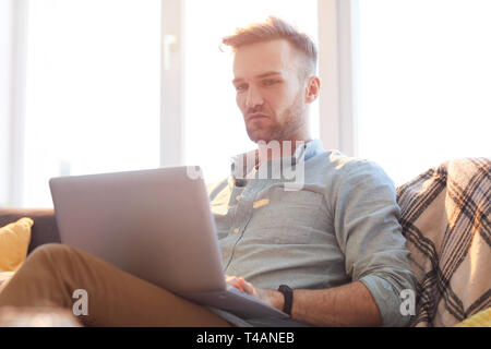Handsome Man Using Laptop in Sunlight Banque D'Images