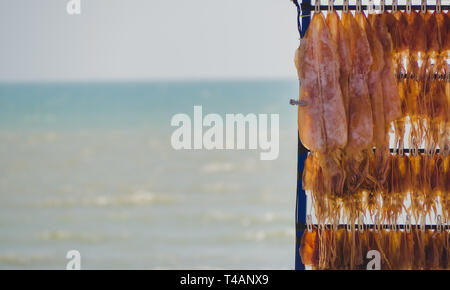 Close up calmars broyés suspendues au-dessus de fruits de mer délicieux en-cas sur la plage. Banque D'Images