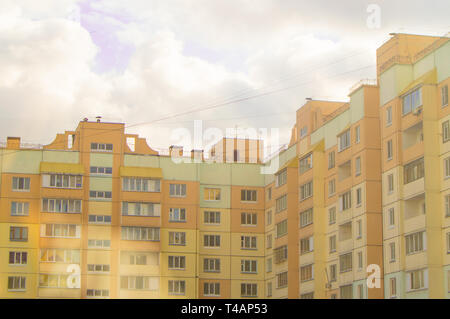 Bâtiment moderne de plusieurs étages maison de brique jaune, le coin intérieur d'un immeuble résidentiel avec balcons, contre le ciel avec nuages, vue de dessous. Banque D'Images