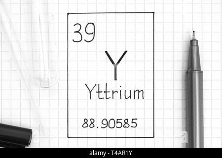 Le tableau périodique des éléments. L'élément chimique de l'écriture l'Yttrium Y avec un stylo noir, tube à essai et pipette. Close-up. Banque D'Images