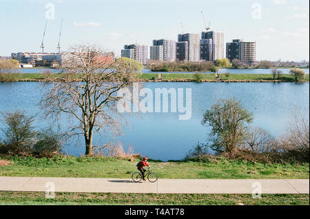 Sur un sentier cycliste par Maynard faible réservoir sur les zones humides de Walthamstow, nord-est de Londres, au Royaume-Uni avec de nouveaux appartements dans l'arrière-plan Banque D'Images