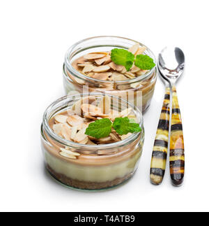 Mini cheesecakes au caramel dans un pot de verre isolé sur fond blanc Banque D'Images