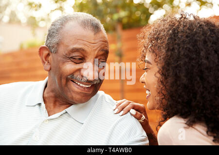 Hauts homme noir et sa petite-fille adultes laughing outdoors, portrait Banque D'Images