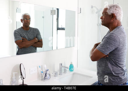 Déprimé malheureux homme Senior à la réflexion en miroir de salle à Banque D'Images