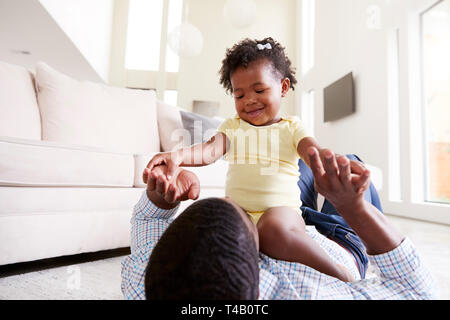 Petite fille jouant avec le père dans le salon à la maison Banque D'Images