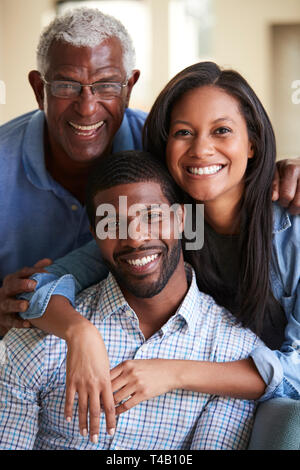 Portrait Of Smiling Senior père avec son fils et sa fille adultes Hugging At Home Banque D'Images
