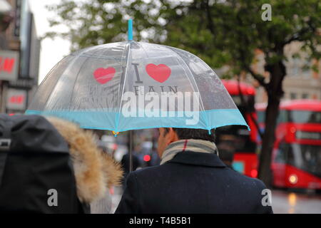 Parapluies dans les Shoppers transportant la pluie à Oxford Street, London, UK Banque D'Images
