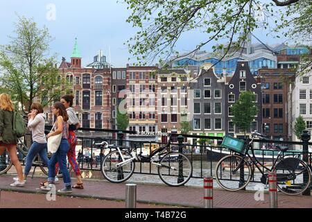 AMSTERDAM, Pays-Bas - 8 juillet 2017 : les touristes à pied par la rivière Amstel à Amsterdam, Pays-Bas. Amsterdam est la capitale des Pays-Bas. Banque D'Images