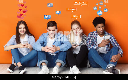 Les adolescents avec les smartphones en pleine discussion dans les réseaux sociaux, orange wall Banque D'Images