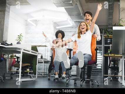 Groupe de jeunes collaborateurs bénéficiant de course président au travail Banque D'Images