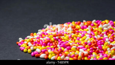 Arrière-plan coloré bonbon sucré chocolat multi couleur fond noir avec motif coloré isolé d'écran HD Banque D'Images