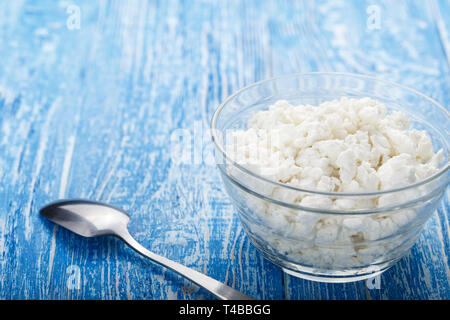Fromage blanc frais dans une assiette sur un fond de bois. lieu pour le texte produit laitier nutritif. Banque D'Images