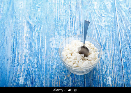 Fromage blanc frais dans une assiette sur un fond de bois. lieu pour le texte produit laitier nutritif. Banque D'Images
