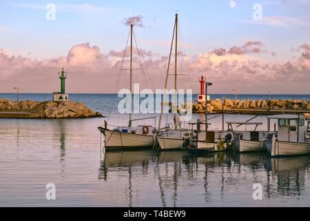 Port de Cala Bona, bateaux de pêche avec des réflexions, ciel nuageux et la lune, Mallorca, Espagne. Banque D'Images