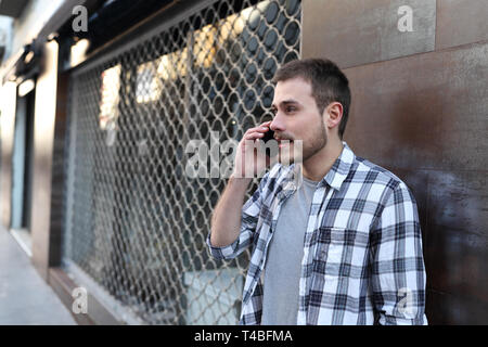 Portrait of a serious man talking on smart phone dans la rue Banque D'Images