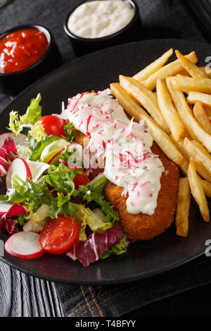 La goberge dans la chapelure frit avec des frites et salade fraîche gros plan sur une plaque verticale sur la table. Banque D'Images