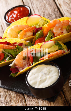 Tacos de maïs aux crevettes, légumes frais et les sauces sur la table verticale. Banque D'Images