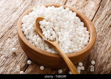 Perles de tapioca sont riches en hydrates de carbone dans un bol sur une table de bois horizontal. Banque D'Images