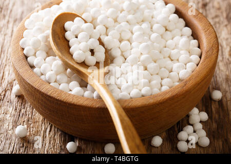 Perles de tapioca bio close-up dans un bol sur une table de bois horizontal. Banque D'Images