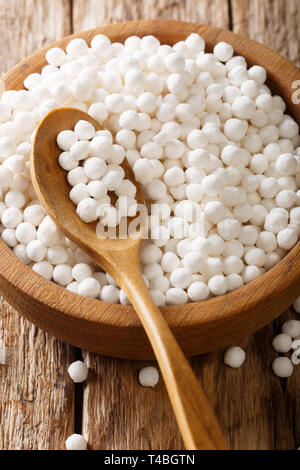 Perles de tapioca close-up dans un bol sur une table en bois vertical. Banque D'Images