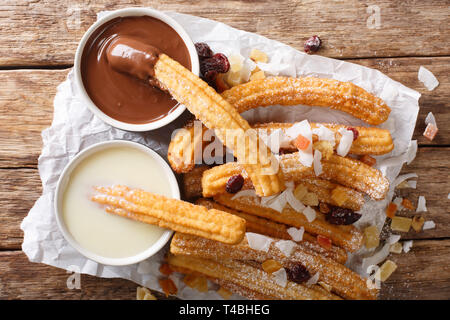 Dessert espagnol churros servi avec du chocolat chaud et de lait concentré sur la table. haut horizontale Vue de dessus Banque D'Images