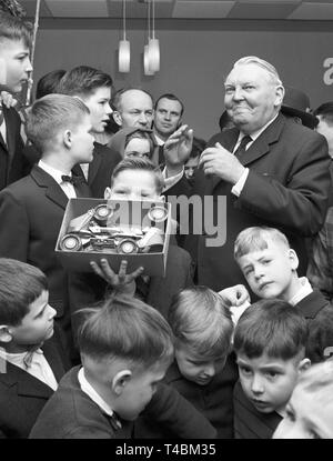 Chancelier Ludwig Erhard visites des orphelins dans un orphelinat à Bonn le 20 décembre en 1963, de les surprendre avec des cadeaux de Noël. La photo montre Ludwig Erhard après la distribution de cadeaux au milieu de la lecture d'enfants. Dans le monde d'utilisation | Banque D'Images