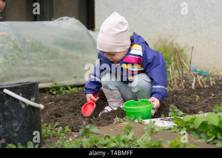 Petite fille explorer le jardin et aider avec le nettoyage de printemps. Banque D'Images