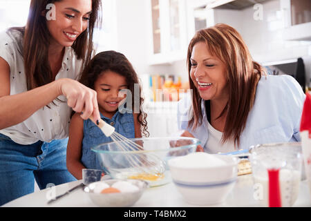 Jeune fille faire un gâteau dans la cuisine avec sa maman et sa grand-mère, Close up Banque D'Images